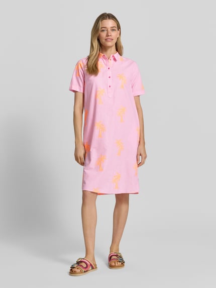 Vrouwenmodel draagt knielang overhemdjurk met knoopsluiting van Milano Italy, katoenmix, recht model, kentkraag, 1/2-mouwen, roze met oranje print, geheel vooraanzicht