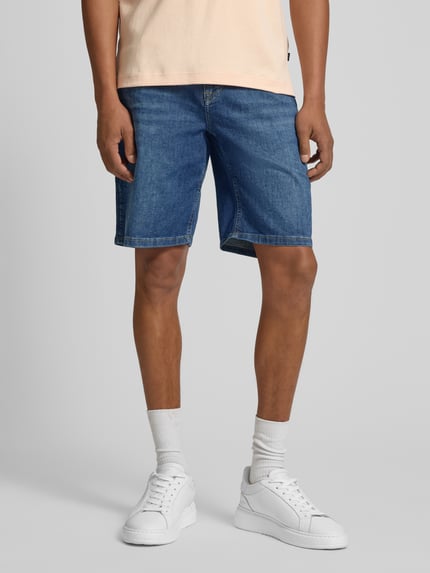 Męskimodel nosi Bermudas im 5-Pocket-Design Modell 'Fort' von JOOP! Collection, mieszanka bawełny z dodatkiem streczu, krój straight fit, zapięcie na guzik i zamek błyskawiczny, szerokość w rozmiarze 32: 48 cm, długość wewnętrzna nogawki w rozmiarze 32: 25 cm, niebieski denim, proste linie, gładka tekstura, całkowite ujęcie od przodu.
