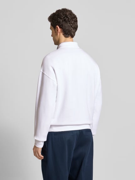 Männermodel trägt Regular Fit Sweatshirt aus Baumwoll-Mix von Polo Ralph Lauren, unifarben weiß, langarm, gerippte Abschlüsse, Ganzkörperansicht Rückansicht.