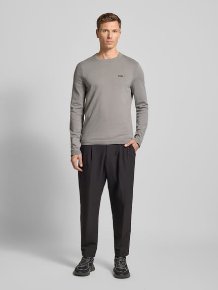 Männermodel trägt Regular Fit Strickpullover aus reiner Baumwolle Modell 'EVER-X' von BOSS Green in Grau, unifarben, Ganzkörperansicht von vorne.