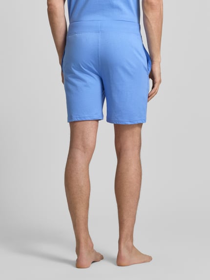 Männermodel trägt Slim Fit Pyjama Shorts aus zuiver katoen Model 'SHORT-SLEEP-BOTTOM' van Polo Ralph Lauren Underwear, look: effen, logostitching, tunnelkoord, zij-steekzakken, Ganzkörperansicht Rückansicht.