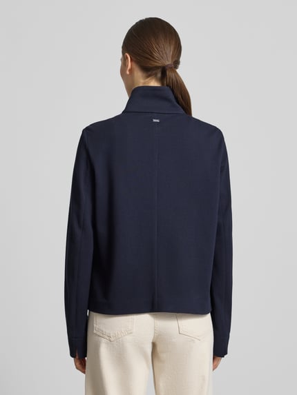Vrouwenmodel draagt Regular Fit Jacke mit Stehkragen van WHITE LABEL in donkerblauw, elastische katoenmix, opgestikte zakken, ruglengte 57 cm, borstwijdte 50 cm, mouwlengte 65 cm, geheel knoopsluiting, rugaanzicht volledige lichaamsopname.