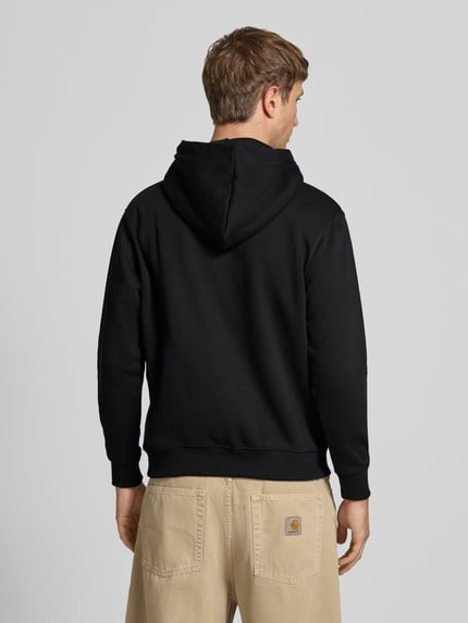 Männermodel trägt Relaxed Fit Hoodie aus Baumwoll-Mix mit Motiv-Print von CHILL PILL in Schwarz, elastische Abschlüsse, Rückenansicht. Kontext: Herren Hoodie, Känguru-Tasche, Rückenlänge 68 cm, Ärmellänge 61 cm.
