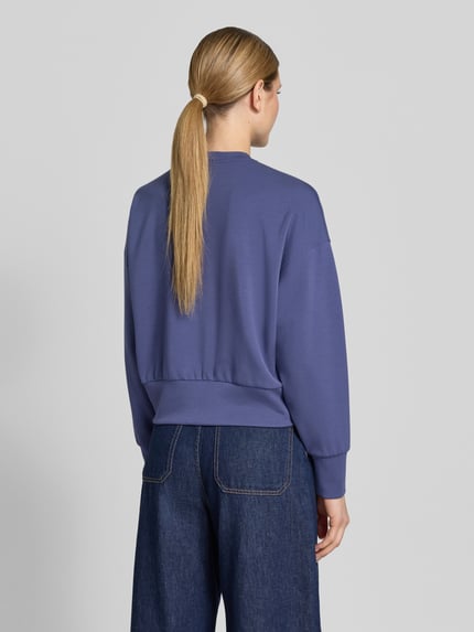 Vrouwenmodel draagt Relaxed Fit Sweatshirt uit viscose-mix model 'Nima' van MOS MOSH in blauw met elastische boorden, logodetail, elastische viscose, ronde halslijn, detailopname rugaanzicht.
