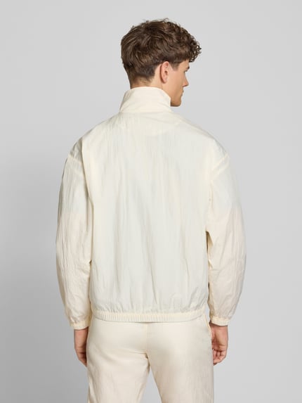 Männermodel trägt Herren Jacke von SERGIO TACCHINI, Regular-Fit, Stehkragen, Modell 'Nayla', cremefarben, elastische Abschlüsse, Ganzkörperansicht Rückansicht.