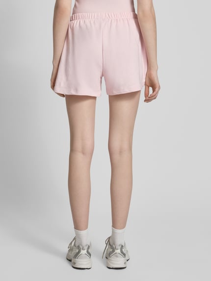 Frauenmodel trägt Kurze Sweatshort mit Stickerei von REVIEW in Rosa aus Baumwoll-Mix mit Viskose-Anteil, Regular-Fit, elastischer Bund, Ganzkörperansicht Rückansicht.
