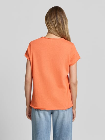 Frauenmodel trägt T-Shirt mit Rollsaum und V-Ausschnitt von Smith and Soul in Orange, Reine Baumwolle, Regular-Fit, Rückenlänge 63 cm, Ganzkörperansicht Rückansicht.