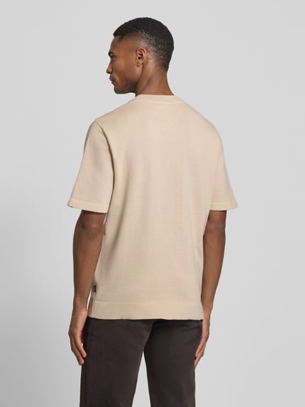 Männermodel trägt T-Shirt mit Label-Detail Modell 'MILANO' von Jack & Jones Premium in Beige, gerader Schnitt, Rückenansicht, Ganzkörperansicht Rückansicht.