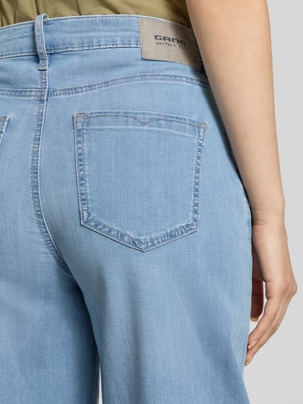 Frauenmodel trägt Barrel Fit Jeans mit Label-Detail Modell 'Carlotta' von Gang, Baumwoll-Mix mit Stretch-Anteil, Eingrifftaschen, Nahaufnahme Rückansicht.