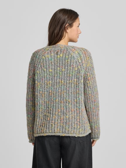 Modelka kobieca nosi Regular Fit Strickjacke mit Woll-Anteil od Smith and Soul, szary melanż z kolorowymi nićmi, gruby splot, widok z tyłu, Ganzkörperansicht Rückansicht.