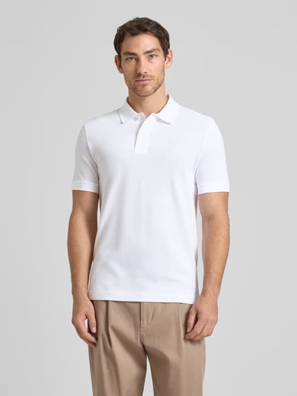 Männermodel trägt Regular Fit Poloshirt aus reiner Baumwolle Modell 'PALLAS' von BOSS, Optik: Unifarben, Piqué-Struktur, Ganzkörperansicht von vorne.