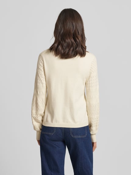 Frauenmodel trägt Regular Fit Pullover aus Viskose-Mix Modell 'Milos' von Vila in Strick-Optik mit Lochmuster, Langärmelig, Rundhalsausschnitt, elastische Abschlüsse, cremefarben, Rückenlänge 54 cm, Ärmellänge 64 cm, Ganzkörperansicht Rückansicht.