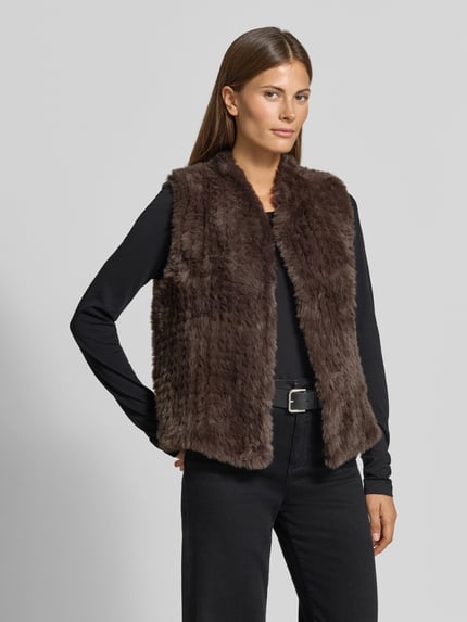Vrouwenmodel draagt Regular fit bodywarmer van imitatiebont van comma, opstaande kraag, mouwloos design, donkere tinten, Ganzkörperansicht van voren, ruglengte maat S 58 cm, schouderbreedte 37 cm, borstwijdte 48 cm.