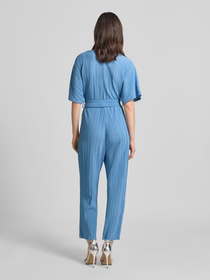 Vrouwenmodel draagt Regular Fit Jumpsuit met V-hals model 'Olinda' van YAS in lichtblauw met plisséstructuur, korte mouwen, afneembare stoffen riem, getailleerde pasvorm, materiaal met fijne lijnen, rugaanzicht, Ganzkörperansicht Rückansicht.