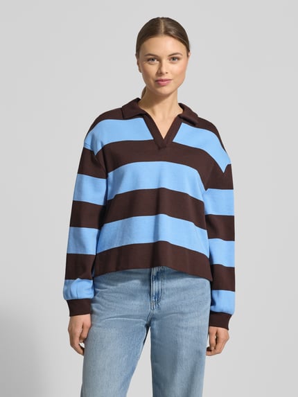 Modelka kobieca ma na sobie bluzę Sweatshirt mit Umlegekragen Modell 'Glocki' od OPUS, mieszanka bawełny i elastanu, prosty krój, wykładany kołnierz z dekoltem w serek, elastyczne wykończenia, szerokie niebiesko-brązowe pasy, tekstura gładka, widok całej sylwetki z przodu.