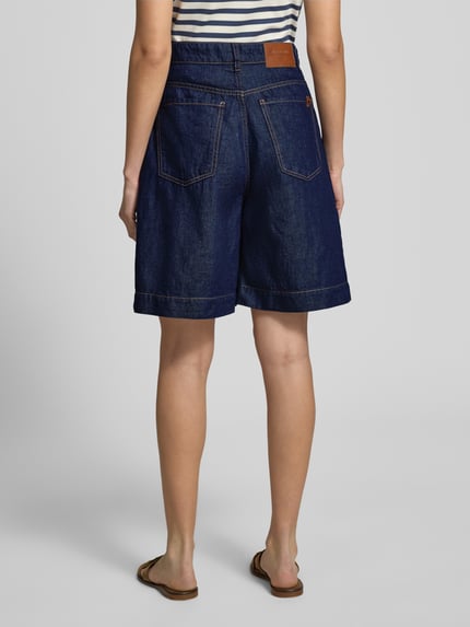 Frauenmodel trägt Wide Leg Bermudashorts aus Baumwoll-Leinen-Mix Modell 'OZONO' von Weekend Max Mara, denim, 5 kieszeni, szlufki, guzik i zamek błyskawiczny, aplikacja z marką, mieszanka bawełny i lnu, widok całej sylwetki z tyłu.