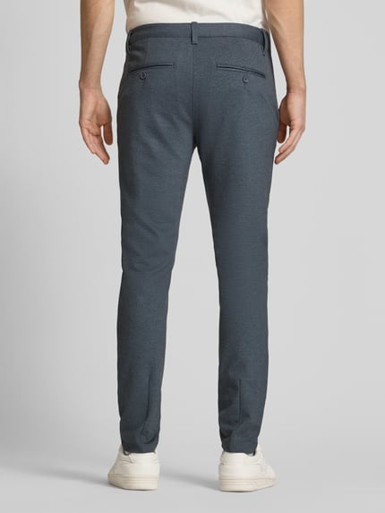Männermodel trägt Slim Fit Chino aus Viskose-Mix Modell 'MARK' von Only & Sons in Melange-Optik mit Gesäßtaschen, Ganzkörperansicht Rückansicht.