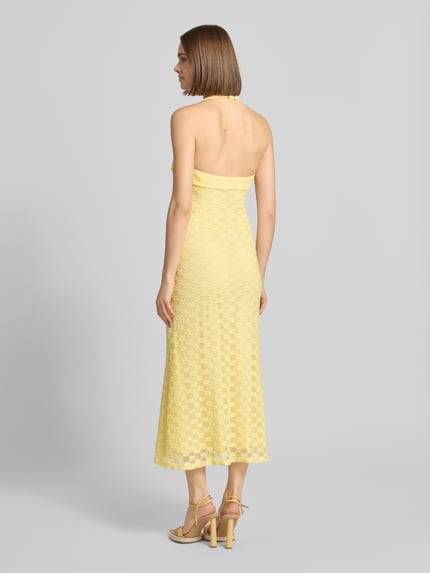 Frauenmodel trägt Bardot Neckholder-Midikleid Modell 'MARIKO' aus Material-Mix, Figurbetont, gelb, Strukturmuster, Ganzkörperansicht Rückansicht.
