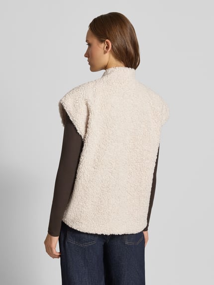 Modelka kobieca nosi kamizelkę Regular Fit w stylu imitacji futerka model 'NAYA' od ONLY, beżowa faktura, widok całej sylwetki od tyłu, kamizelka damska ONLY.