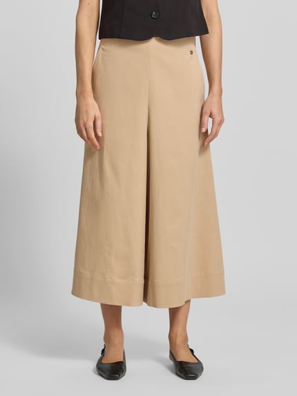 Frauenmodel trägt Culotte mit elastischem Bund Modell 'Zuri Tenca' von MOS MOSH aus Baumwoll-Lyocell-Anteil, Loose-Fit, französische Eingrifftaschen, Label-Detail, beige Farbton, glatte Struktur, Ganzkörperansicht von vorne.