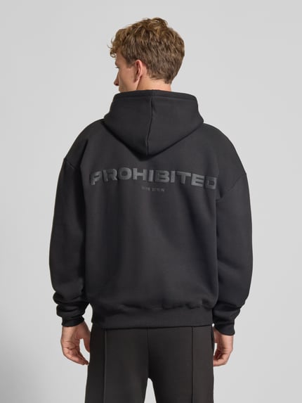 Männermodel trägt Relaxed Fit Hoodie aus Baumwoll-Mix mit Label-Detail von PROHIBITED, Schwarz, elastische Abschlüsse, Ganzkörperansicht Rückansicht.