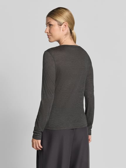 Frauenmodel trägt Longsleeve in semi-transparenter Optik von MYON, Lyocell-Mix mit Woll-Anteil, tailliert, Rückansicht, Ganzkörperansicht.