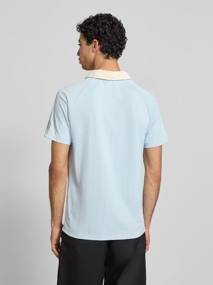 Męski t-shirt Regular Fit T-Shirt mit Umlegekragen Modell 'Heritage' od KARL KANI, jasnoniebieski, wykładany kołnierz, wyhaftowane logo, długość tyłu w rozmiarze M: 70 cm, Ganzkörperansicht Rückansicht.