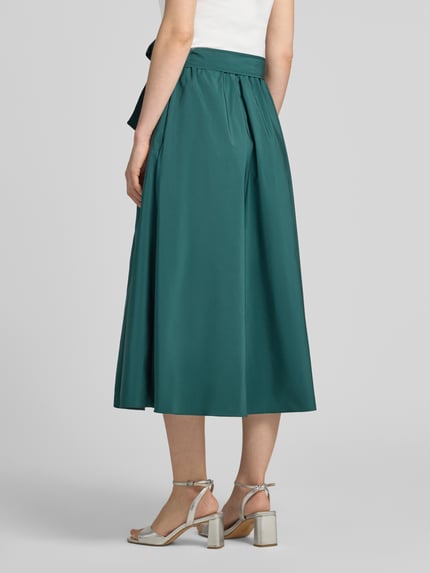Frauenmodel trägt Ausgestellter Midi-Rock mit Baumwoll-Anteil Modell 'ALPACA' von Weekend Max Mara in Dunkelgrün, glatte Textur, Ganzkörperansicht Rückansicht. Damen Midi-Rock von Max Mara.