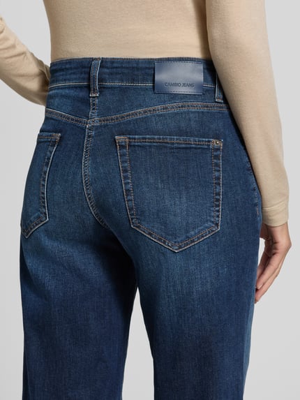Frauenmodel trägt Regular Fit Barrel Jeans mit Used-Waschung Modell 'ELIN' von CAMBIO, dunkelblauer Denim mit Faded-Effekt, Detailaufnahme Rückansicht.