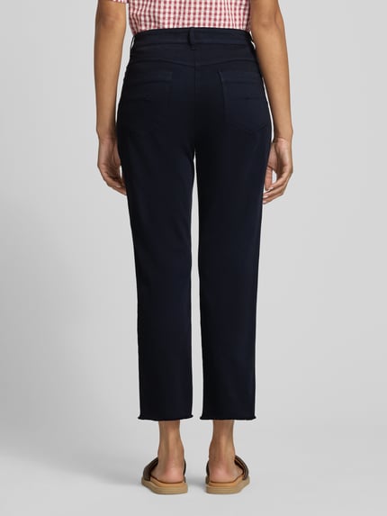 Frauenmodel trägt Chino mit Fransensaum von Marc Cain, dunkelblau, Slim Fit, Baumwoll-Mix, Gesäßtaschen, Fransensaum, Ganzkörperansicht Rückansicht.