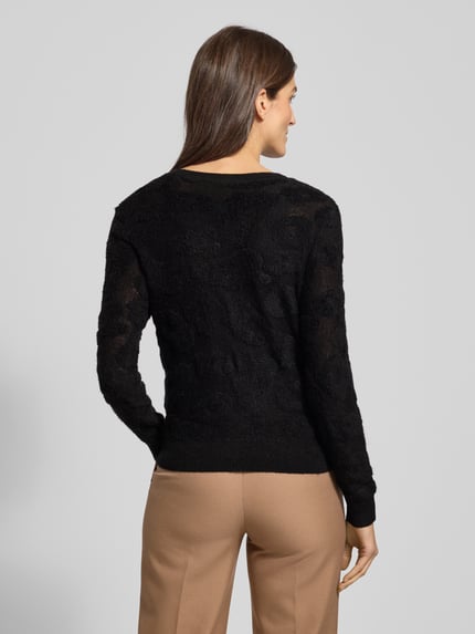 Frauenmodel trägt Strickjacke mit Knopfleiste von Luisa Cerano, Material-Mix mit Lyocell-Anteil, Regular-Fit, Gerippte-Abschlüsse, Rundhalsausschnitt, Rückenlänge 47 cm, Ärmellänge 60 cm, schwarze Farbe, feine Struktur, Ganzkörperansicht Rückansicht.