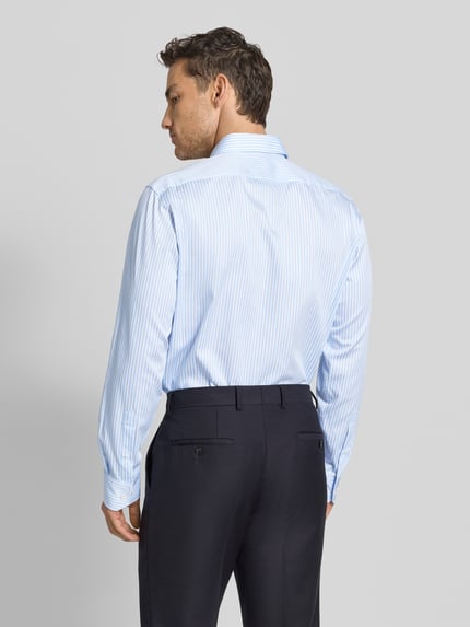 Männermodel trägt Regular Fit Businesshemd aus reiner Baumwolle Modell 'JOE' von BOSS, hellblau mit feinen Streifen, Ganzkörperansicht Rückansicht.