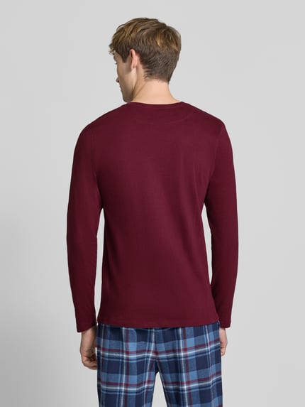Männermodel trägt Slim Fit Longsleeve aus puur katoen van Christian Berg Men, effen bordeaux, met lange mouwen, ruglengte maat M 70 cm, ganzkörperaanzicht achteraan.