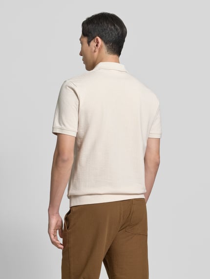 Mannelijk model draagt Regular Fit poloshirt uit puur katoen van s.Oliver RED LABEL, look: effen, materiaal: jersey, labelpatch, polokraag, V-hals, korte mouw, gestructureerd, pasvorm: regular fit, detailopname rugaanzicht.