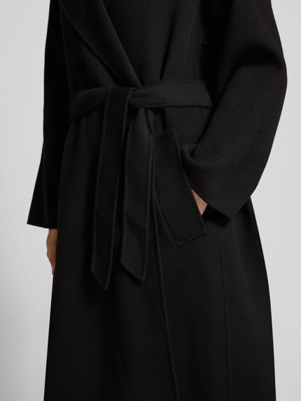 Frauenmodel trägt schwarzen Regular Fit Mantel aus Schurwoll-Mix Modell 'OPEROSO' von Weekend Max Mara, Nahaufnahme Oberkörper.