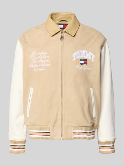 Produktfoto, Relaxed Fit College-Jacke aus echtem Leder von Tommy Jeans in Lederoptik mit Umlegekragen, Label-Schriftzug, Applikation, Label-Stitching, Reißverschluss, seitlichen Paspeltaschen, Napoleontasche, Materialverarbeitung Veloursleder und Glattleder, Farbe Beige und Weiß, Passform Relaxed-Fit