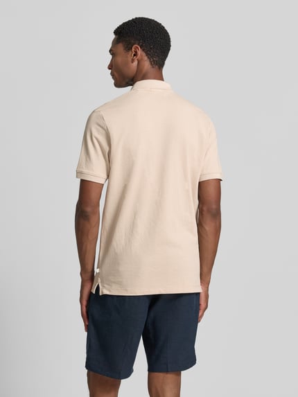 Männermodel trägt Regular Fit Poloshirt aus Baumwoll-Mix von s.Oliver RED LABEL in Beige, glatte Textur, Ganzkörperansicht Rückansicht.