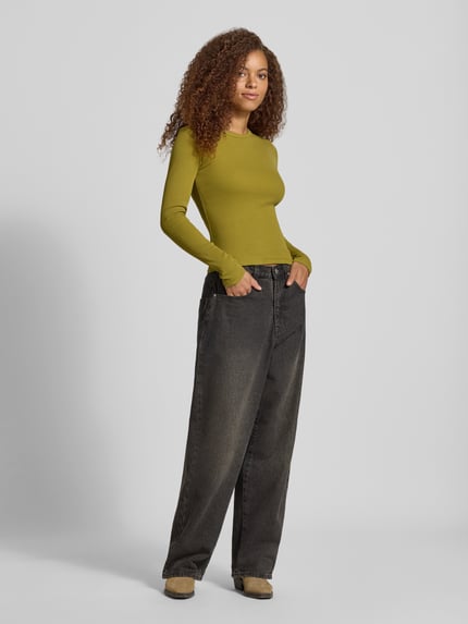Vrouwenmodel draagt shirt met lange mouwen van mix van katoen en elastaan, skinny fit, Model 'FREYA' van JJXX, riblook, groene tint, ronde hals, ruglengte bij maat S 50 cm, volledige lichaamsvoorzijde.