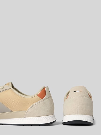 Produktfoto, Low Top Sneaker mit Velours-Optik-Applikationen Modell 'NITAN' von BOSS, unifarbene Optik, Profilsohle, Label Print, Logo-Stitching, Schnürung, abgerundete Schuhspitze, flacher Absatz, Textilstruktur und Wildlederdetails, beige und sandfarbene Töne.