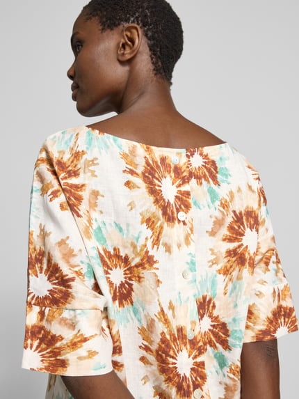 Frauenmodel trägt Bluse aus Leinen mit U-Boot-Ausschnitt von Christian Berg Woman, buntes Batik-Muster, Loose-Fit, 1/2-Arm, Rückenansicht
