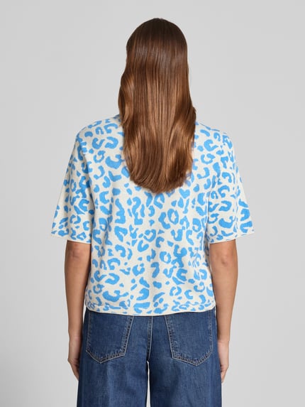 Modelka nosi Relaxed Fit Shirt aus Viskose-Anteil Modell 'Mayas' od Vila, mieszanka materiałów z dodatkiem wiskozy, imitacja dzianiny, rękaw o dł. 1/2, zwierzęcy nadruk na całej powierzchni, okrągły dekolt, długość tyłu w rozm. S 54 cm, długość rękawów 29 cm, widok całej sylwetki z tyłu.