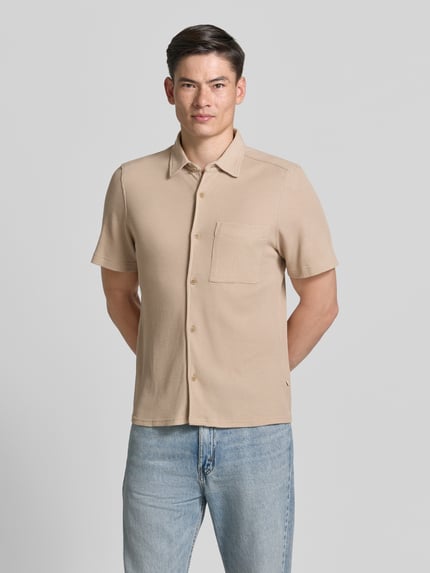 Männermodel trägt Regular Fit Freizeithemd aus Baumwoll-Mix von s.Oliver RED LABEL, Optik: Unifarben, Waffelstruktur, Kurzarm, Knopfleiste, Kentkragen, Brusttasche, Materialverarbeitung: Piqué, Ganzkörperansicht von vorne.