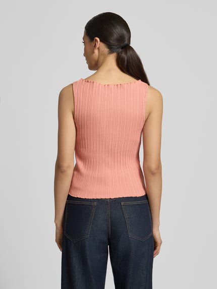 Modelka nosi top z dzianiny z fakturowanym wzorem, okrągły dekolt, mieszanka bawełny i elastanu, krój regular fit, Scotch & Soda, długość tyłu w rozmiarze S: 50 cm, długość rękawa w rozmiarze S: 38 cm, widok całej sylwetki od tyłu.