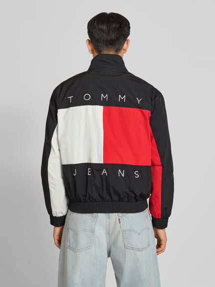 Männermodel trägt Regular Fit Blouson mit Logo-Stitching von Tommy Hilfiger in Optik: Unifarben, farbige Panels, Ganzkörperansicht Rückansicht
