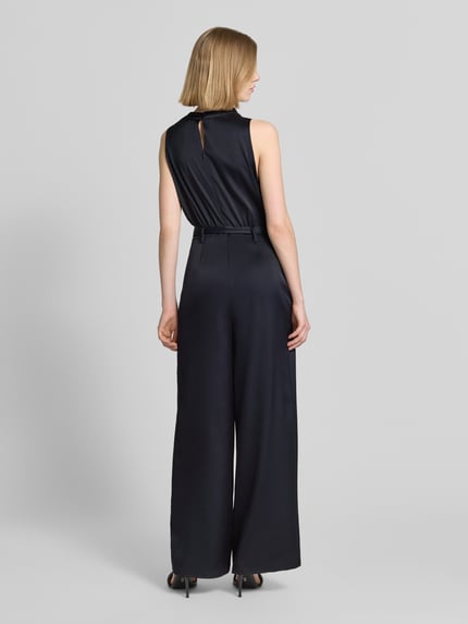 Vrouwenmodel draagt Jumpsuit aus Satin im ärmellosen Design van comma in zwart met tailleband, taps toelopende fit, productdetails, volledige lichaamsweergave achterkant.