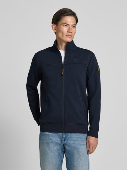 Männermodel trägt Sweatjacke mit Stehkragen und Label-Patch von PME Legend in Dunkelblau, Strukturmuster, Reißverschlusstaschen, Ganzkörperansicht von vorne.