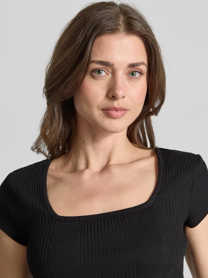 Vrouwenmodel draagt T-Shirt in Ripp-Optik mit Karree-Ausschnitt van JAKE*S STUDIO WOMAN, zwart, slim fit, ribstructuur, katoenen-elastaanmix, close-up bovenlichaam.