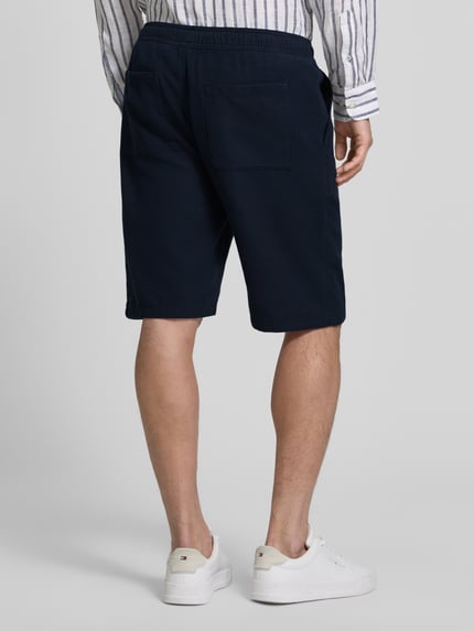 Mężczyzna nosi Shorts aus Baumwolle mit elastischem Bund von JAKE*S STUDIO MEN, granatowy kolor, krój regular fit, bawełna, elastyczny pas, tunel na sznurek, Szerokość w rozmiarze M: 47 cm, długość wewnętrzna nogawki w rozmiarze M: 26 cm, tekstura gładka, widok całej sylwetki z tyłu