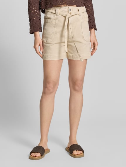 Vrouwenmodel draagt Shorts met opgestikte zakken en strikriem van Jake*s Casual, relaxed fit, lichte beige tint, voorkant, detailopname bovenbenen.