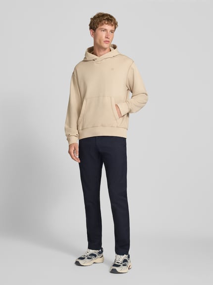 Männermodel trägt dunkelblaue Skinny Fit Hose aus Baumwoll-Mix Modell 'SID' von Carhartt Work In Progress, Ganzkörperansicht von vorne. Baumwoll-Mix mit Stretch-Anteil, Knopf- und Reißverschluss, seitliche Eingrifftaschen, Gesäßtaschen.